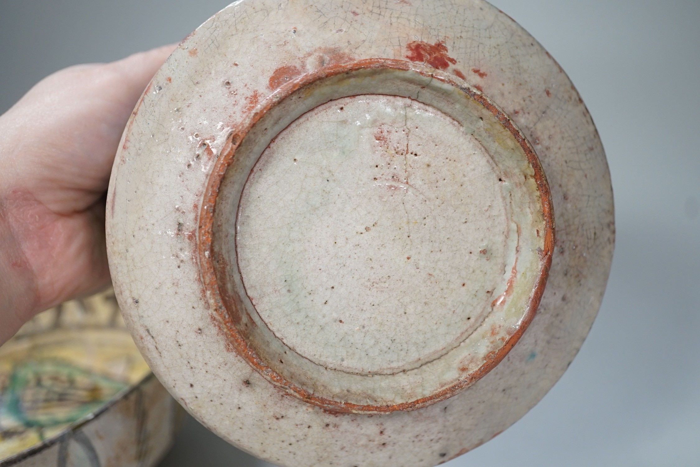 An Islamic Persian bowl with turquoise blue leaf design, 15cm diameter, together with a section of an Islamic tile, and another Islamic bowl, possibly Kashan. Tallest 11cm